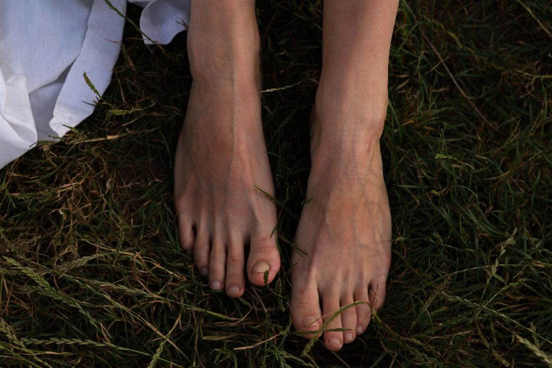 Damp grass, bare soil and stone underfoot outdoors