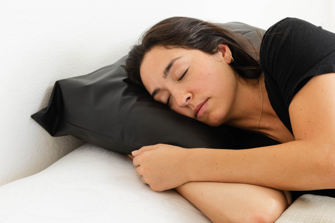 A woman sleeping peacefully on a black Earthing grounding pillow cover