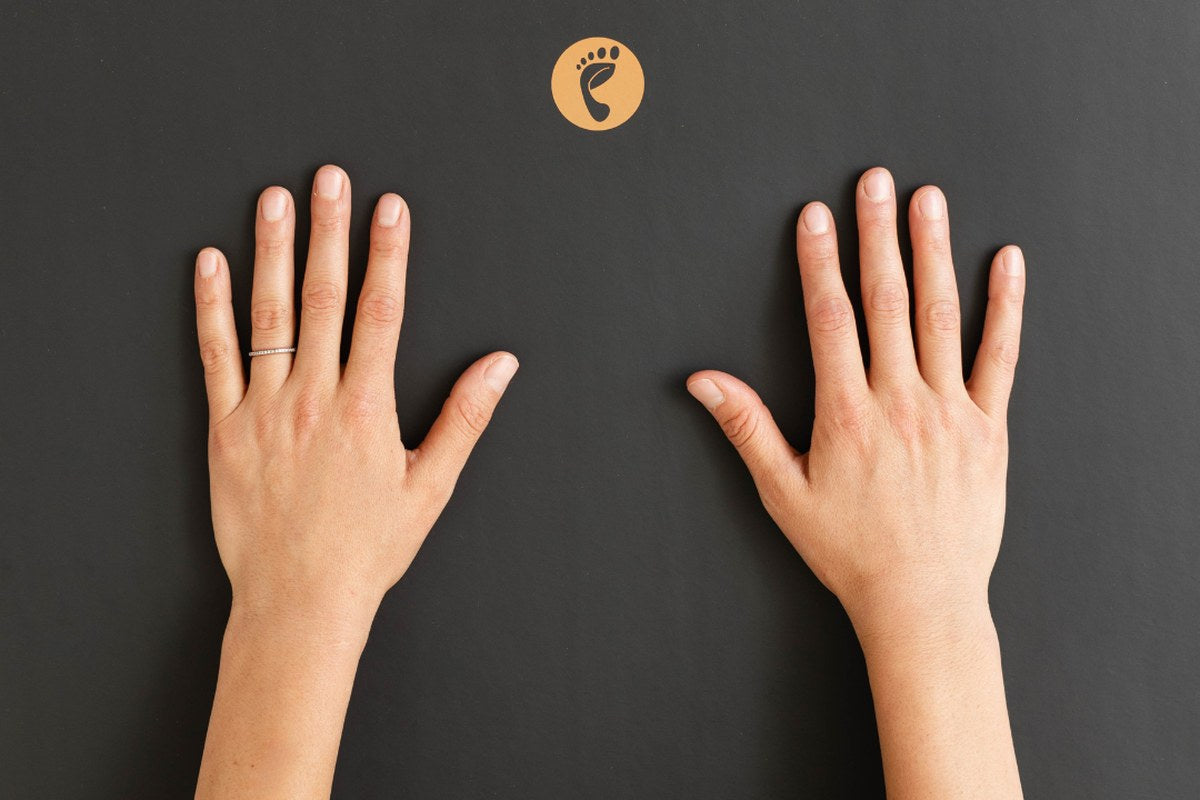 Overhead view of two hands resting flat on a black Earthing grounding mat